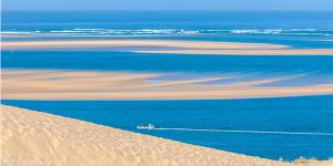 Un bateau naviguant devant la Dune du Pilat