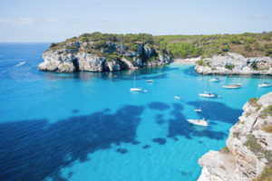 Bateaux et voiliers au mouillage dans une crique aux eaux turquoise