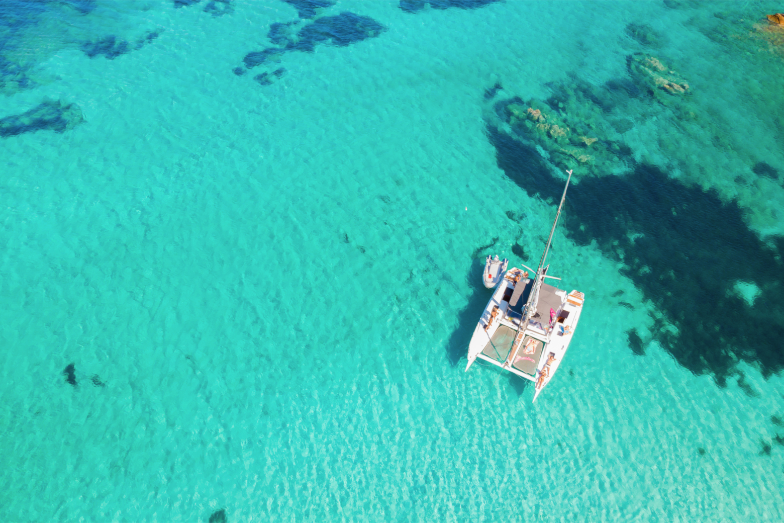 Vue aérienne d'un catamaran dans une eau turquoise