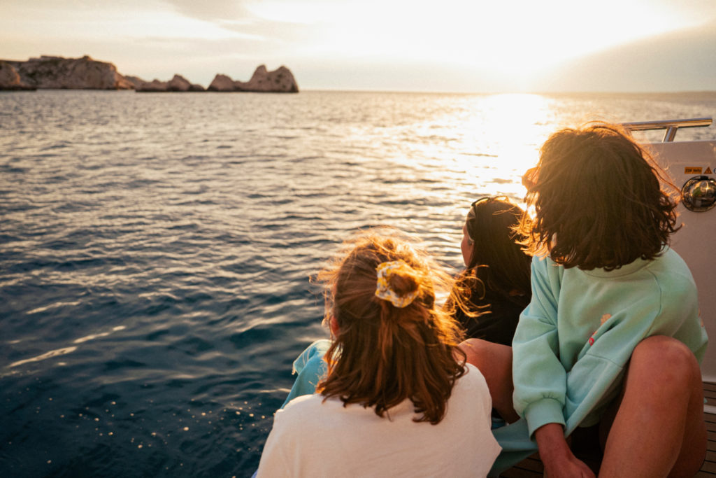 Des personnes profitant d'un coucher de soleil depuis un bateau