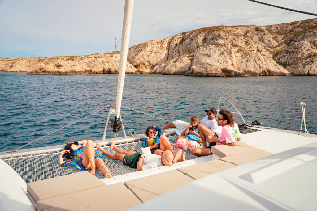Groupe de personnes se détendant à bord d'un catamaran au mouillage