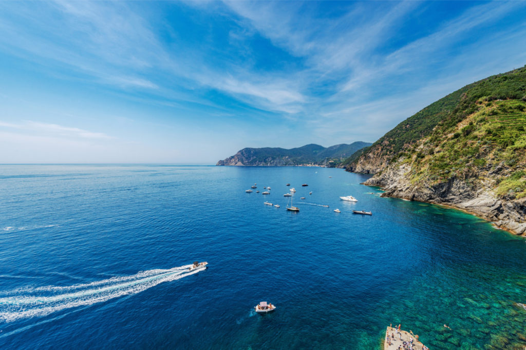 Vue panoramique d'une baie bordée de falaises avec plusieurs bateaux naviguant en mer